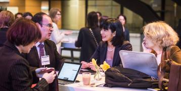 People speaking around a table at an event